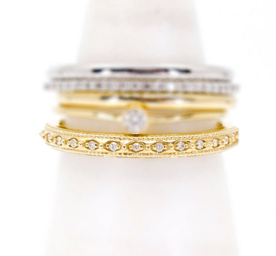 Load image into Gallery viewer, 14k yellow gold diamond band with milgrain detail stacked with other bands on a ring cone.
