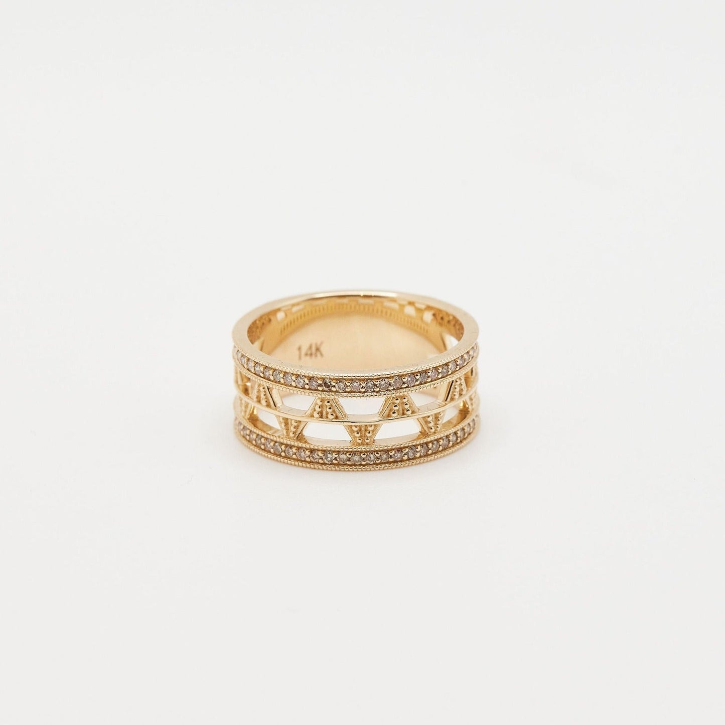 10mm wide champagne diamond and yellow gold band with cut outs and milgrain texture details on white background