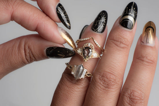 3 diamond rings on a model's hand, grey photo background